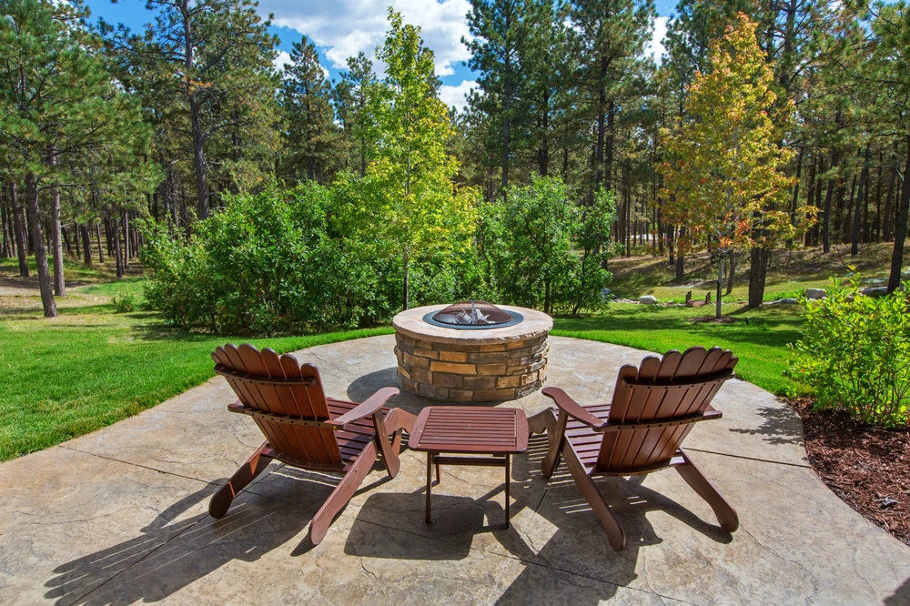Concrete patios with a centered fire pit, showing proper construction with control joints and level finishing.